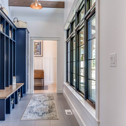 Blue-painted stylish cabinets and mudroom cabinets on the hallway